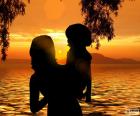 Μαμά με το γιο της στην αγκαλιά της να βλέπουν ένα υπέροχο ηλιοβασίλεμα στη λίμνη